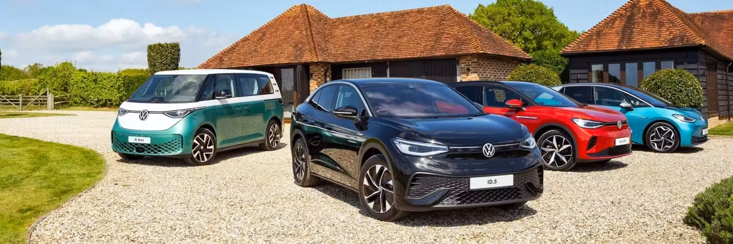four VW electric vehicles on a driveway