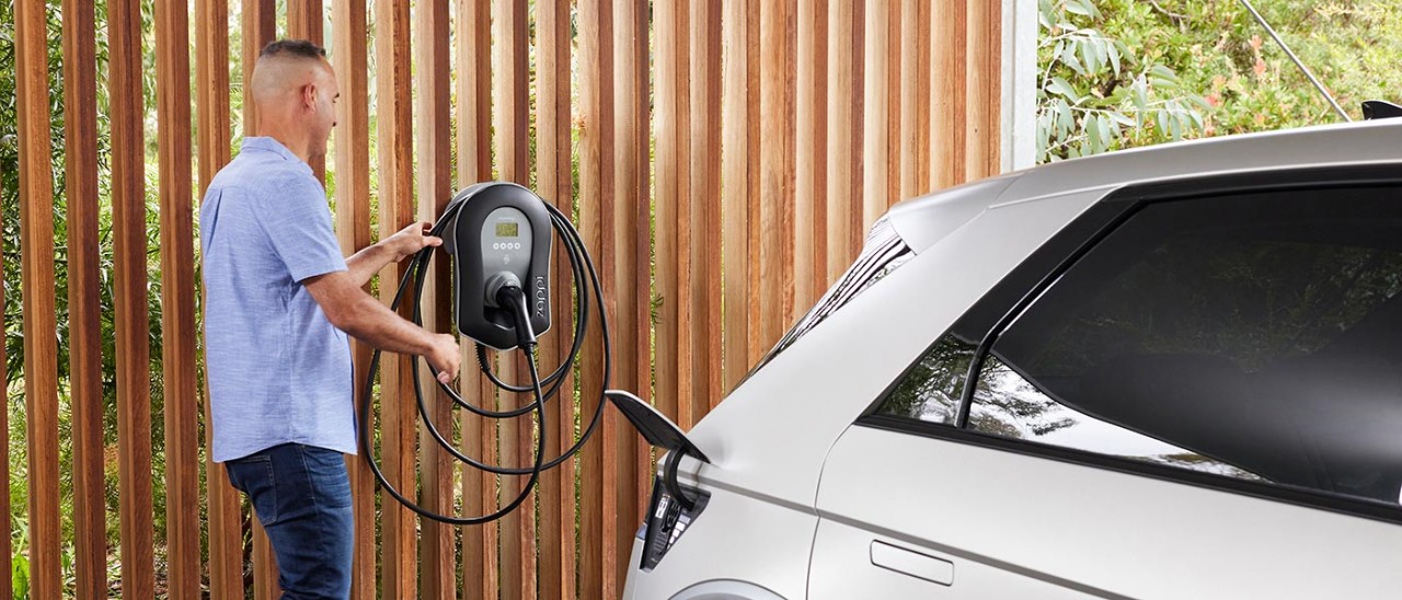 man using ev charger mounted on wall