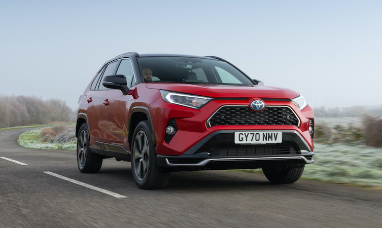 Red Toyota RAV4 Plug-in Hybrid driving along wintery country road