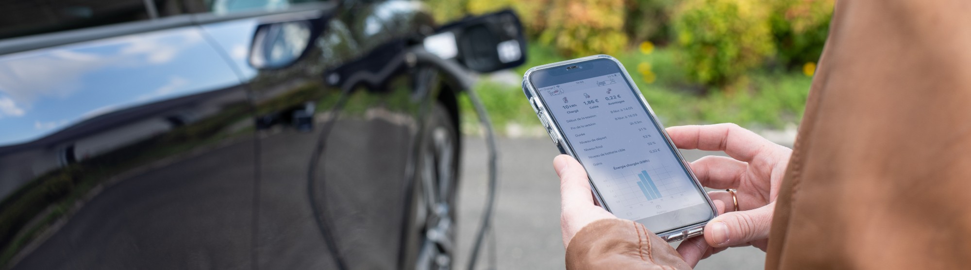 woman holding phone showing ev charging app