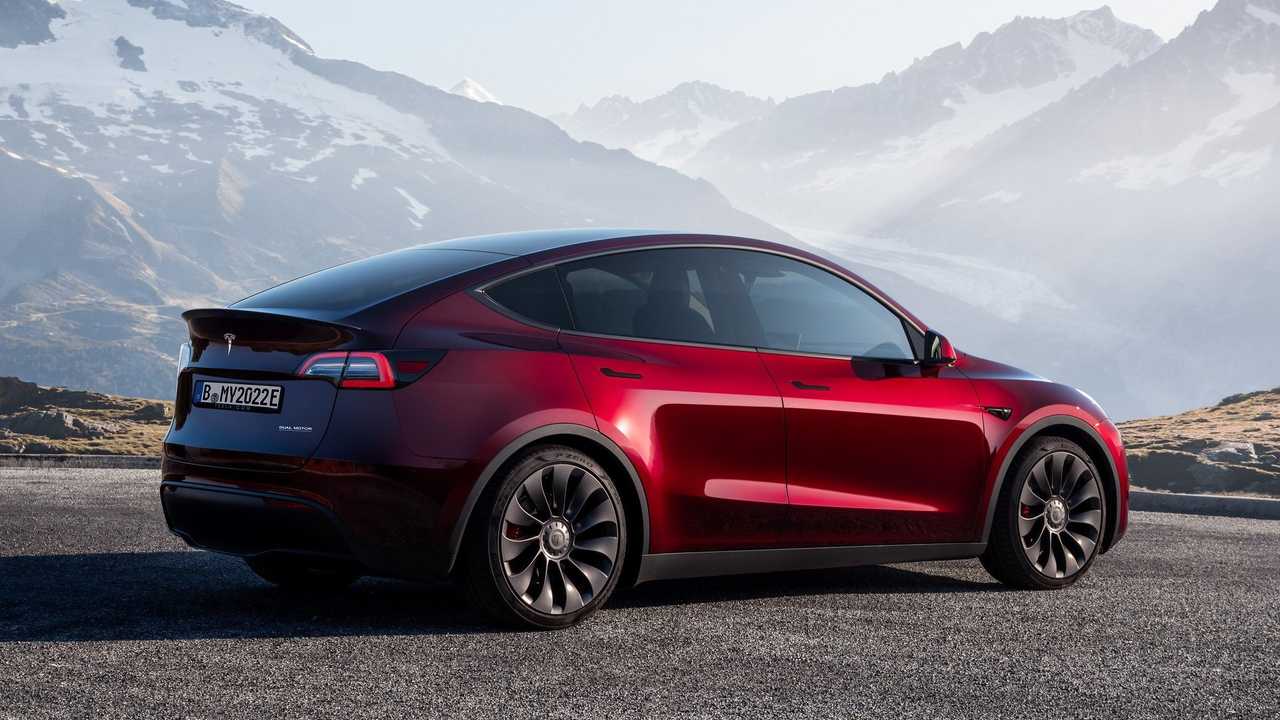 Red Tesla Model Y parked near mountains